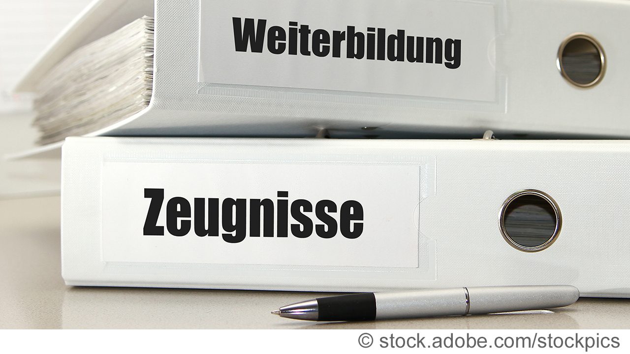 Dokumentenordner mit Weiterbildungsunterlagen und Zeugnisen auf einem Tisch